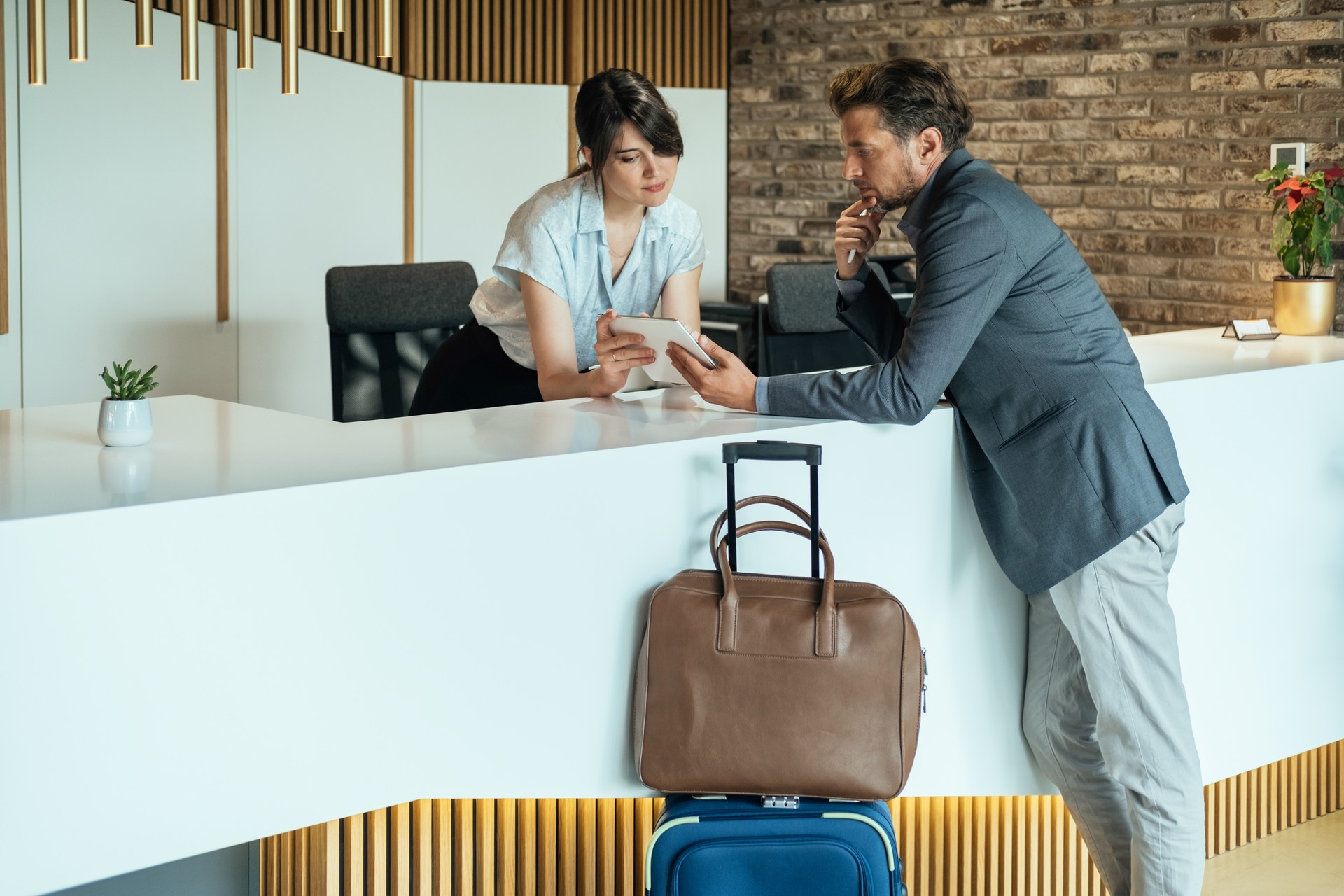 Businessman Using Digital Tablet for Checking In at Hotel